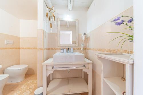 a bathroom with a sink and a toilet and a mirror at B&B Gallipoli Vecchia in Gallipoli