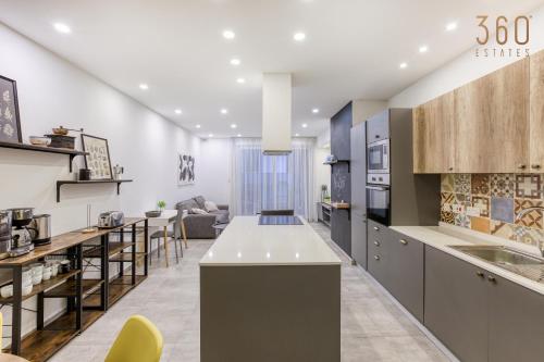 een keuken met een aanrecht en een woonkamer bij Designer 3BR home with Private Balcony in Gzira by 360 Estates in Il-Gżira