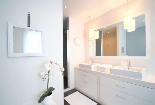 - une salle de bains blanche avec deux lavabos et un miroir dans l'établissement Rooftop Flat w/ outdoor terrasse, à Courbevoie