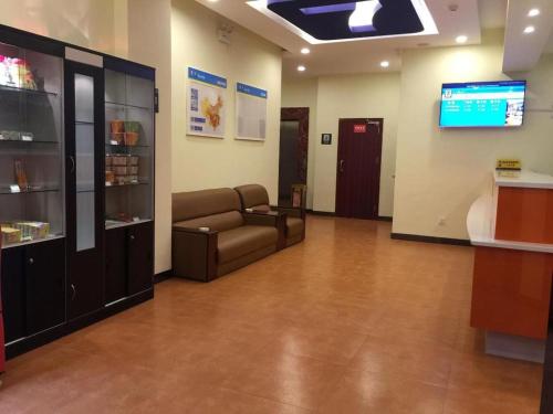a waiting room with a couch and a tv at 7 Days Inn Xingyi Wanfenglin Xiawutun in Xiawutun