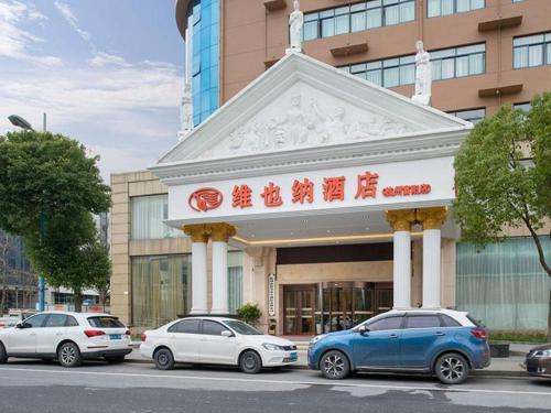 a building with cars parked in front of it at Vienna Hotel Hangzhou Fuyang In-Time in Fuyang
