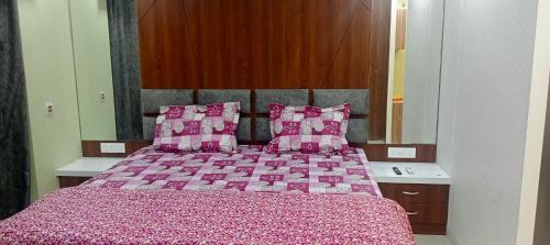 a bedroom with a large bed with pink pillows at Xanadu studio Appartment 904 in kolkata