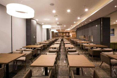 a row of tables and chairs in a restaurant at The Artstay Seogwipo Harbor in Seogwipo