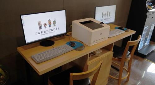 a desk with a computer and a printer on it at The Artstay Seogwipo Harbor in Seogwipo