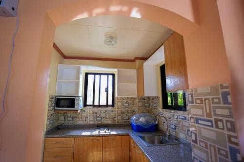 cocina con fregadero y microondas en Hillside Villa, en Basco