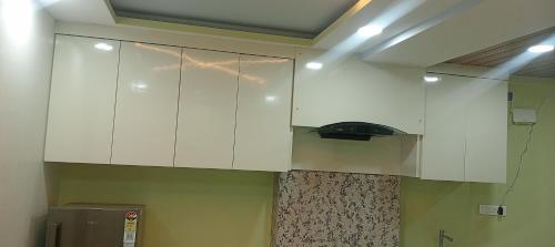a kitchen with white cabinets in a room at Xanadu studio Appartment 904 in kolkata