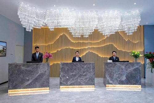 three men in suits sitting at tables in a lobby at danfeng kelly hotel in Shenzhen