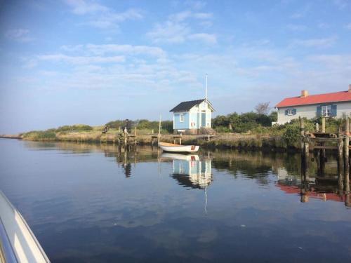 un bateau dans l'eau à côté d'une maison dans l'établissement Cottage by the ocean, à Ängelholm