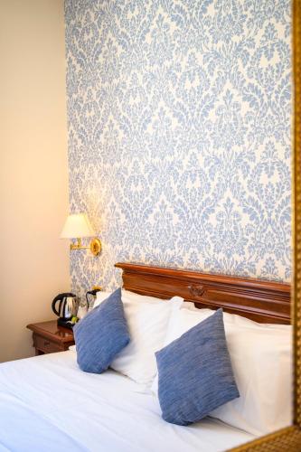 a bedroom with a bed with blue and white wallpaper at Relais Villa Giuliana in Licata