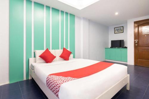 a bedroom with a bed with red and green stripes at OYO 128 d'Builders Rooms Phase 2 in Manila