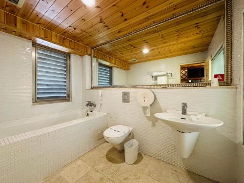 a bathroom with a sink and a toilet and a bath tub at Ivy Motel in Chiayi City