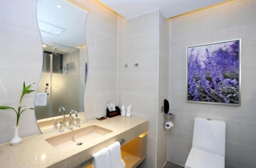 a bathroom with a sink and a large mirror at Lavande Hotels Changzhi City God Temple in Changzhi