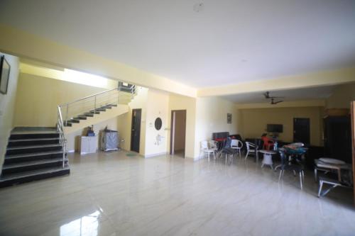 ein Wohnzimmer mit einer Treppe, einem Tisch und Stühlen in der Unterkunft Jha Farm & resorts 