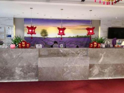 a lobby with a bar with a large painting on the wall at Lavande Hotels Urumqi Xinmin West Street Hongda Plaza in Ürümqi