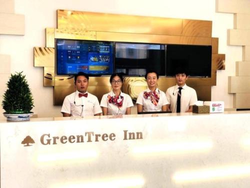 a group of four people standing behind a counter at GreenTree Inn Dongtai Sancang Town in Sancang