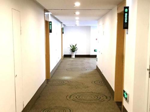 a hallway of an office building with a potted plant at GreenTree Inn Dongtai Sancang Town in Sancang