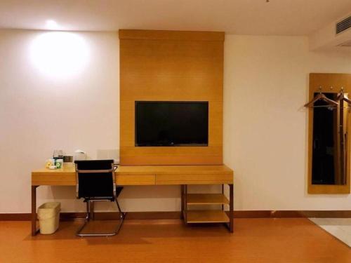 a desk with a television and a chair in a room at GreenTree Inn Dongtai Sancang Town in Sancang