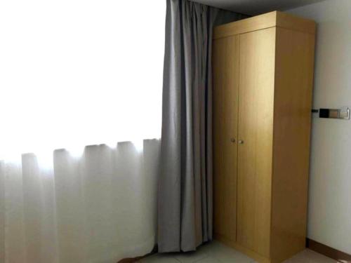 a room with a curtain and a cabinet next to a window at GreenTree Inn Dongtai Sancang Town in Sancang