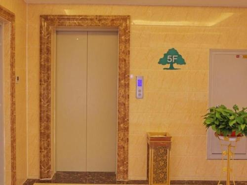 an elevator in a building with a sign on the wall at GreenTree Inn Zhangye Ganzhou Train Station Orthopaedic Hospital in Zhangye