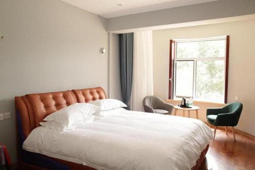 Un dormitorio con una cama grande y una ventana en Yun Brand-Dalian Laodong Park Wuchang Street Ripple Hotel, en Dalian