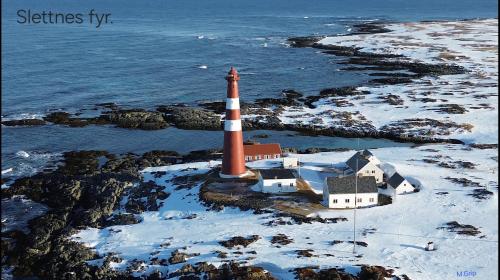 a lighthouse on a rocky island in the water at Gamvik brakkebo as in Gamvik