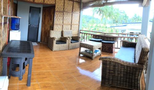 a living room with a table and chairs and a balcony at MIOKI HOMETEL in Batuan