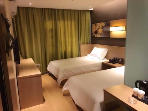 a hotel room with two beds and a window at IU Hotel Kunming Jinma Bijifang Joy City in Kunming
