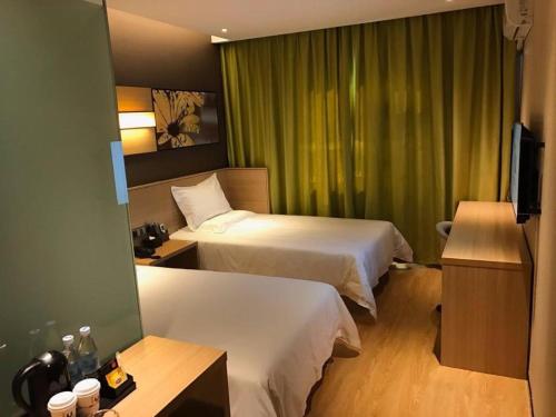 a hotel room with two beds and a television at IU Hotel Kunming Jinma Bijifang Joy City in Kunming