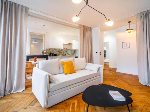 un salon avec un canapé blanc et une table dans l'établissement Le Chic de Dizier, à Nancy