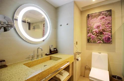 bagno con lavandino e grande specchio di Lavande Hotels·Qingdao Wusi Square a Qingdao