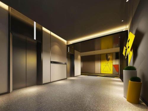 un pasillo vacío de un edificio con una puerta amarilla en IU Hotels·Nanning Zoo Metro Station RT-Mart, en Nanning