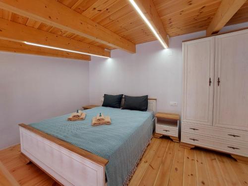 a bedroom with a bed with two towels on it at Roza Stone Studio & Suite in Goníai