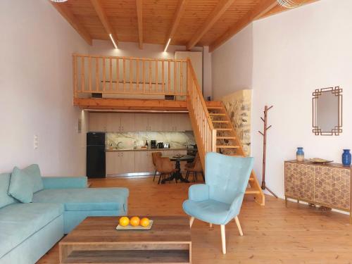 a living room with a couch and a staircase at Roza Stone Studio & Suite in Goníai