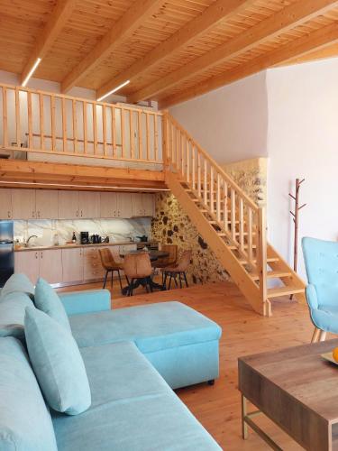 a living room with a blue couch and a staircase at Roza Stone Studio & Suite in Goníai