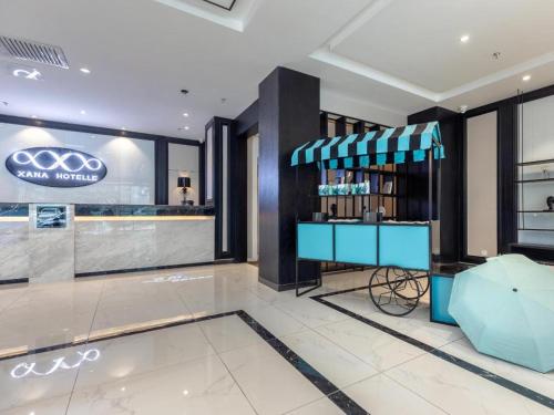a store with a blue cart in a lobby at Xana Hotelle·JiNan Daminghu East Gate Shandong University in Hongjialou