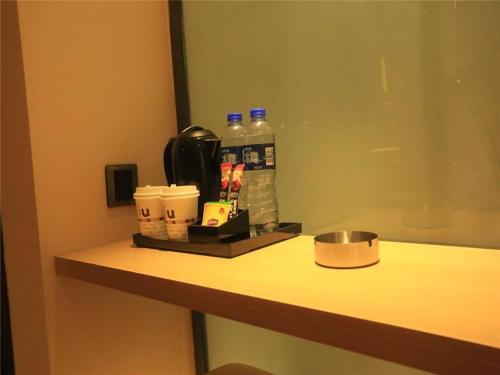 a counter in a hotel room with bottles of water and coffee at IU Hotels Xinzhou Bus Terminal in Xinzhou