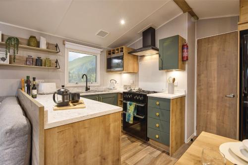 a kitchen with green cabinets and a counter top at Seaton Estate in Arbroath
