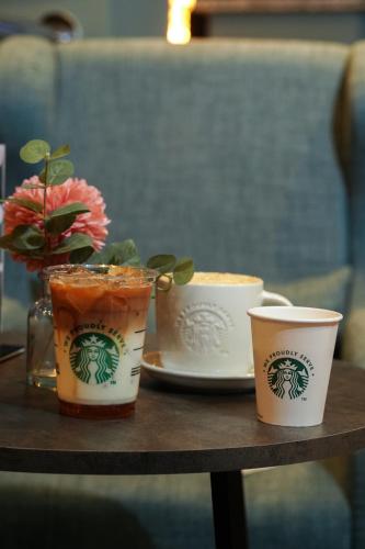 a table with three cups and a vase with flowers at Park hall Hotel & Spa Lancashire, a member of Radisson Individuals in Eccleston