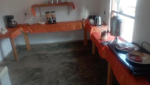 Habitación con 2 mesas de color naranja en una habitación en Dunduzu village lodge, en Mzuzu