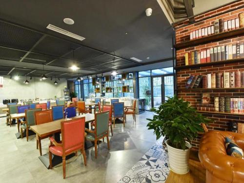a restaurant with tables and chairs and bookshelves at James Joyce Coffetel·Chengdu Chunxi in Chengdu