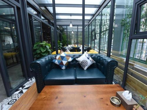 a black leather couch in a room with windows at James Joyce Coffetel·Chengdu Chunxi in Chengdu