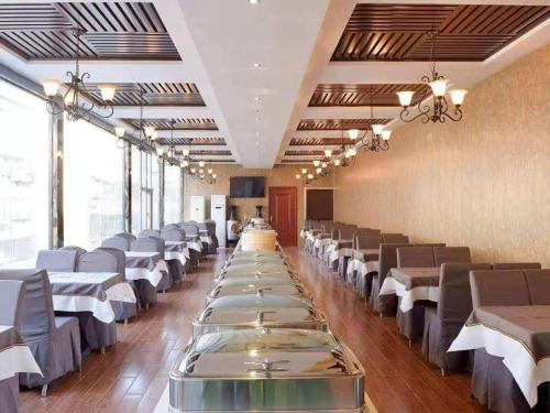 a dining room with long tables and chairs at Xana Lite·Kaifeng Small Song City Millennium City Park in Kaifeng