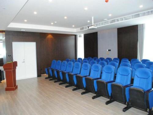 Jinjiang Inn Select Changchun Yuanda Street في تشانغتشون: قاعة اجتماعات مع كراسي زرقاء ومنضدة
