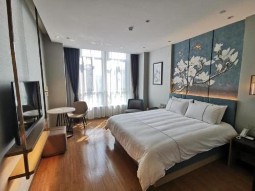 ein Schlafzimmer mit einem großen Bett und einem TV in der Unterkunft Magnotel Jining Jiaxiang Zengzi Avenue in Jiaxiang