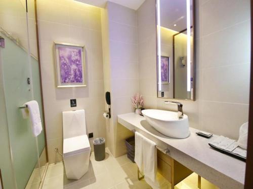 a white bathroom with a sink and a mirror at Lavande Hotels·Mudanjiang People's Park in Mudanjiang