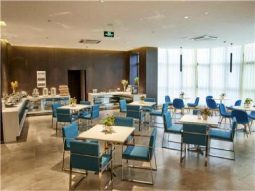 un comedor con mesas y sillas azules en Jinjiang Inn Select Ningbo Hangzhouwan Bridge en Juechuan
