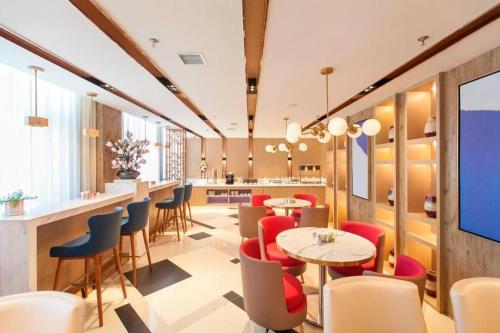 restauracja ze stołami i krzesłami oraz bar w obiekcie Jinjiang Inn Select Changchun Jiutai Minkang Road 