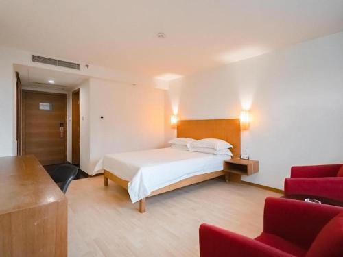 恵州市にあるJinjiang Inn Style Huizhou Xihu Park Walking Streetのベッドと赤い椅子が備わるホテルルームです。