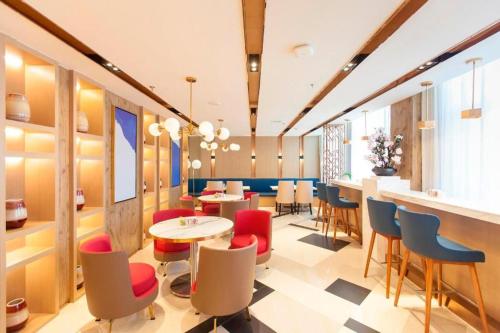 un restaurante con sillas y mesas y un bar en Jinjiang Inn Select Changchun Jiutai Minkang Road 