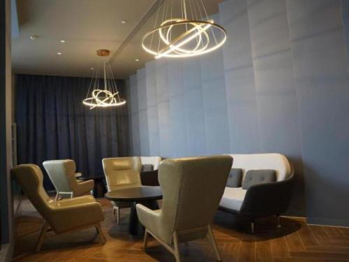 a waiting room with chairs and a table and lights at Jinjiang Inn Select Jiuquan Wanda Plaza in Jiuquan